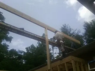 Carpenter setting a ridge beam over a new addition frame — Ice Dam Removal by Roofing Brothers in Lucasville