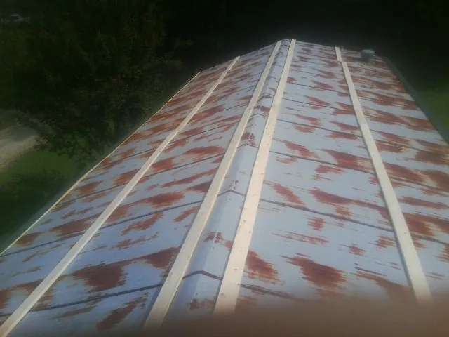 Rusted metal roof panels with new wood purlins before replacement — Storm Damage Roof Repair in Lucasville by Roofing Brothers