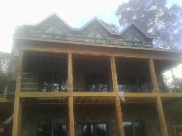 Dormers and porch framing on a large log home under construction — Roof Coating work by our crew in Lucasville