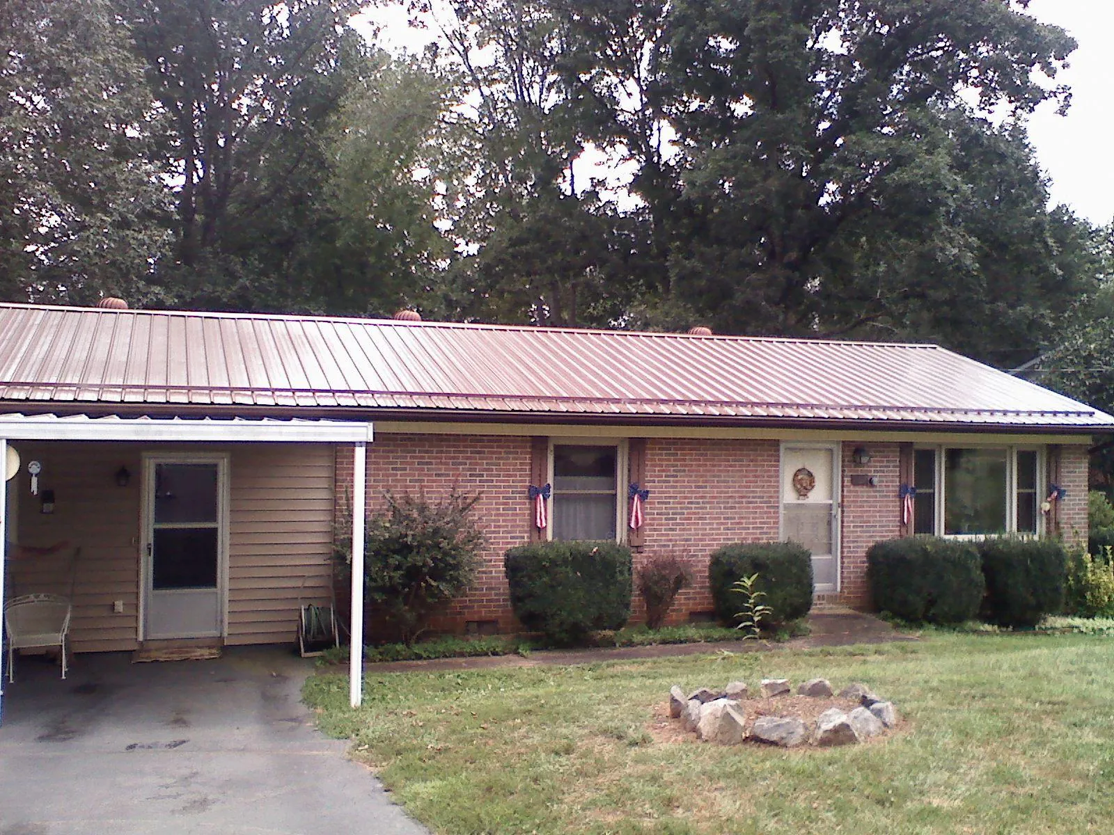 Bronze metal roof and carport on a brick ranch home — Roof Repair work by our crew in Lucasville