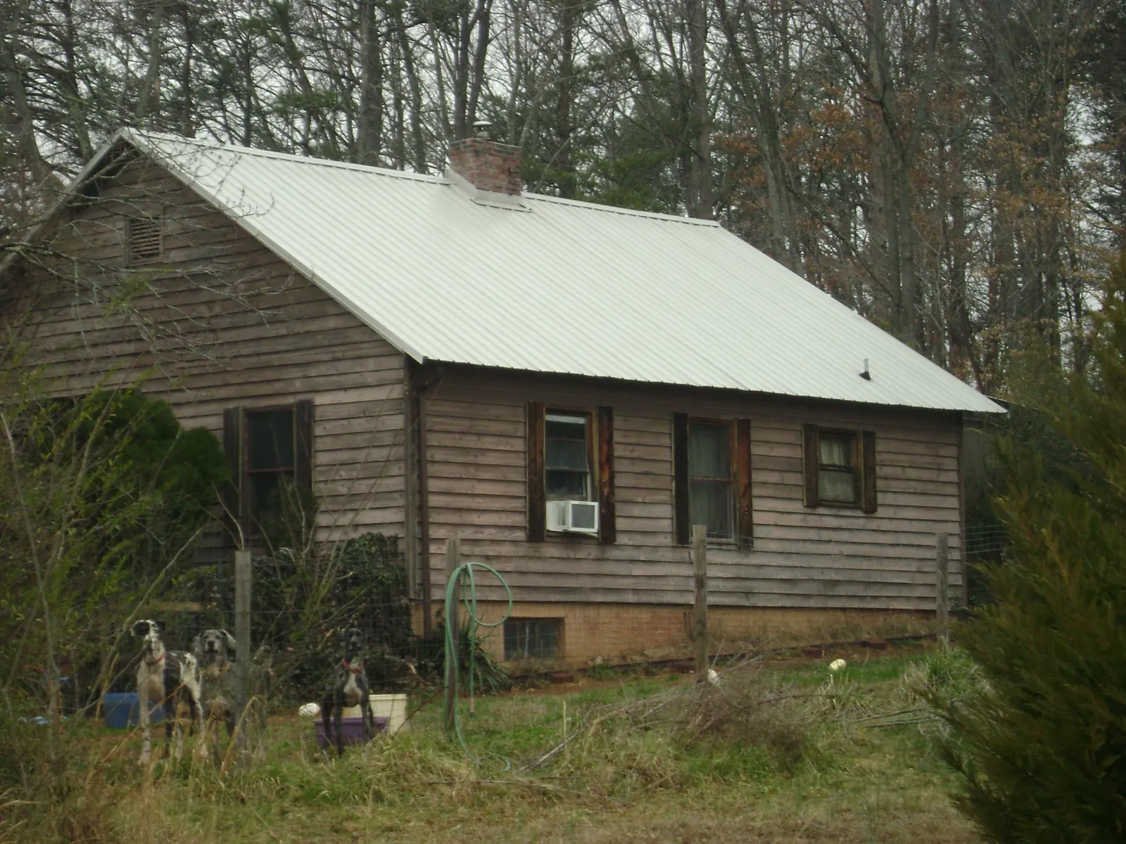 White metal roof on an old wood sided farmhouse, from a Metal Roof Installation job in Lucasville